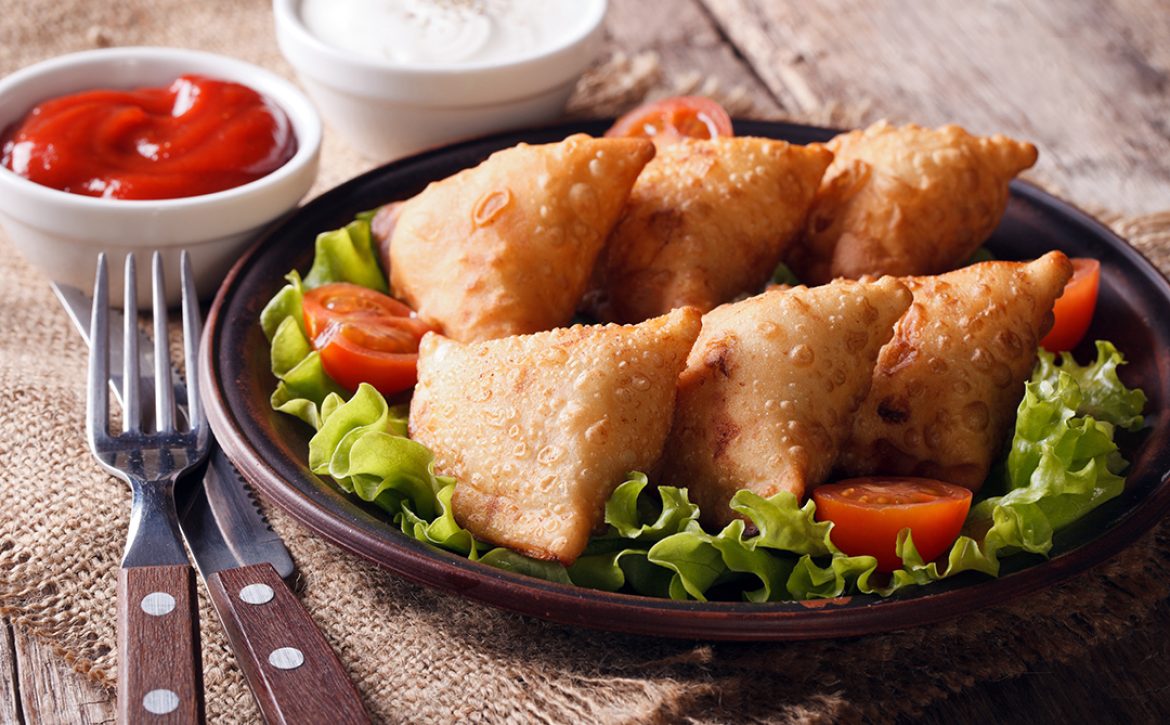 samosa delicious pastry on a plate with tomatoes and lettuce