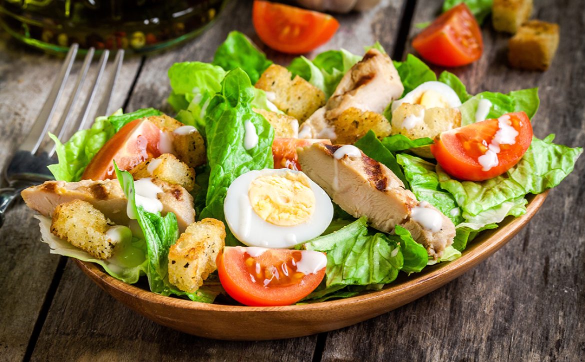 Caesar salad with croutons, quail eggs, cherry tomatoes and gril
